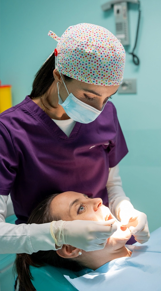 Studio Dentistico Duda | Professionista al lavoro su una paziente durante la pulizia dentale